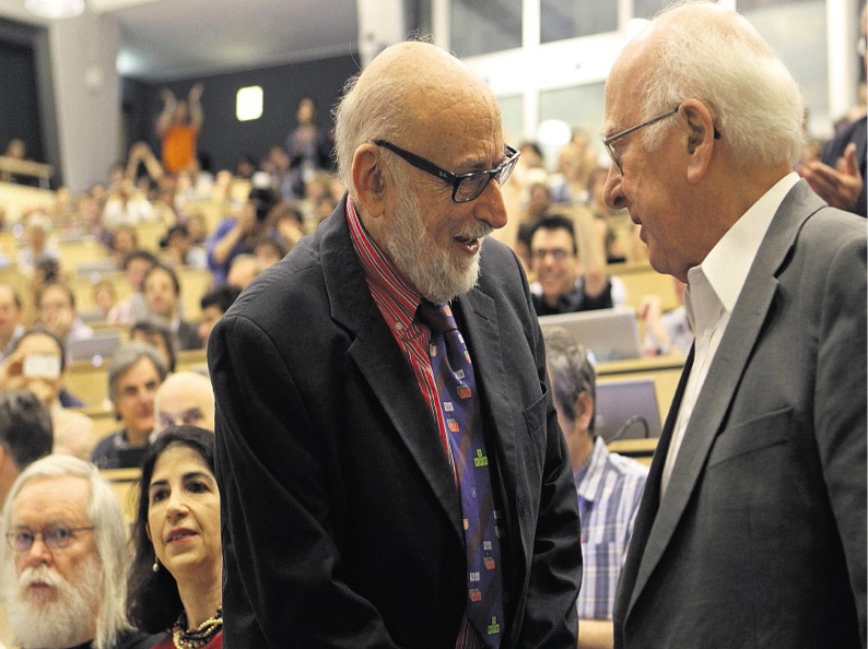 Peter meet François - Professors Higgs and Englert, who collaborated during the 1960s, meet for the first time on 4 July 2012. Notice the back of the room is filled with last years summer students who camped overnight for seats for the Higgs announcement.